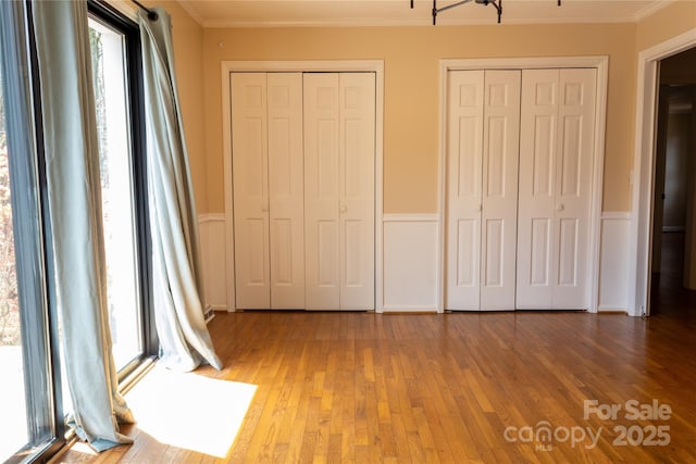1035 Timberlane Dr, Lincolnton, NC 28092 - unfurnished bedroom with two closets, wood finished floors, crown molding, and wainscoting