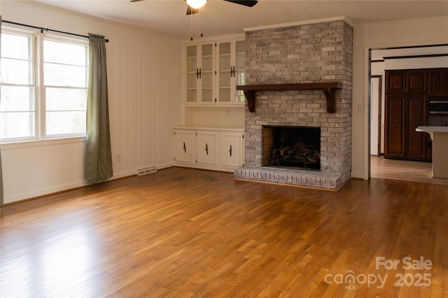 1035 Timberlane Dr, Lincolnton, NC 28092 - unfurnished living room featuring visible vents, a brick fireplace, light wood finished floors, ceiling fan, and ornamental molding