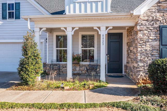 doorway to property with covered porch and a garage