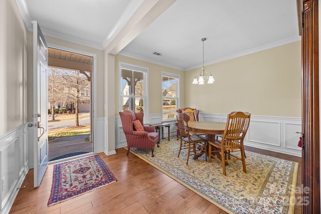 dining area featuring a wealth of natural light, crown molding, hardwood / wood-style flooring, and a notable chandelier