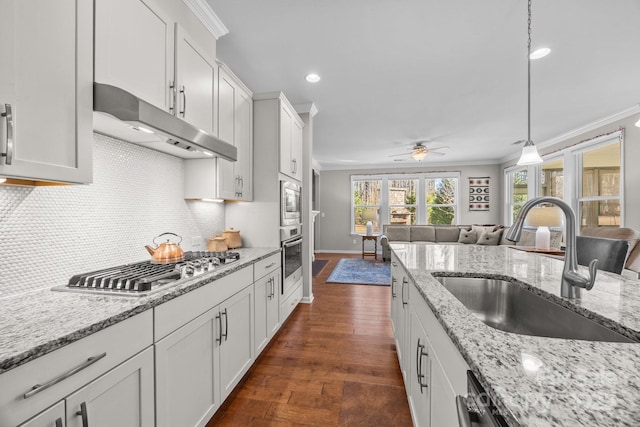 kitchen featuring white cabinets, decorative light fixtures, stainless steel appliances, and sink