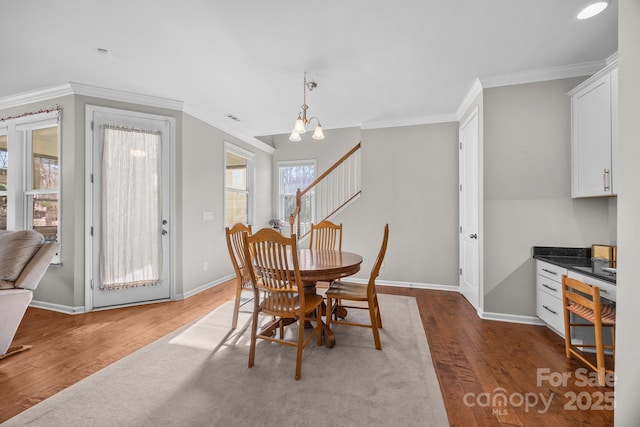 dining area featuring a chandelier, hardwood / wood-style flooring, and ornamental molding