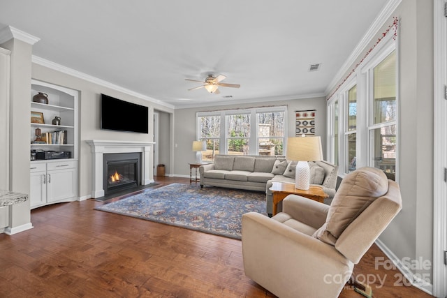 living room with dark hardwood / wood-style flooring, ceiling fan, and ornamental molding