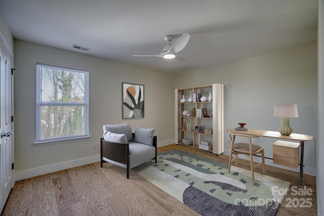 living area with ceiling fan and light hardwood / wood-style floors