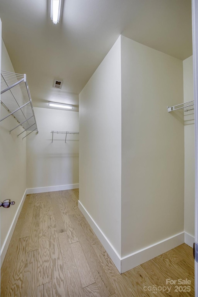 spacious closet with light hardwood / wood-style floors