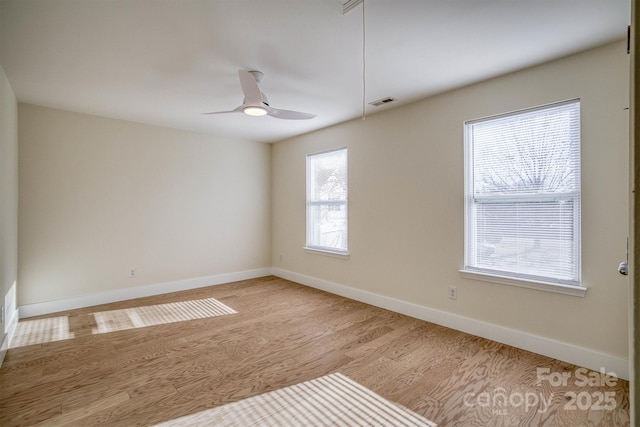 empty room with ceiling fan and light hardwood / wood-style floors