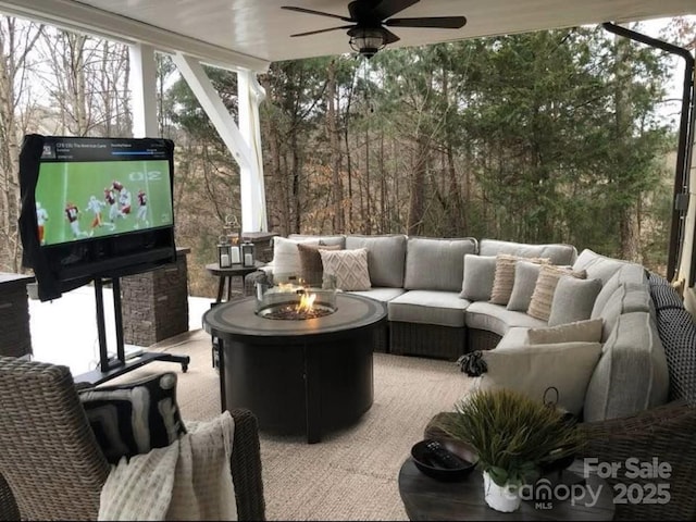 exterior space with ceiling fan and an outdoor living space with a fire pit