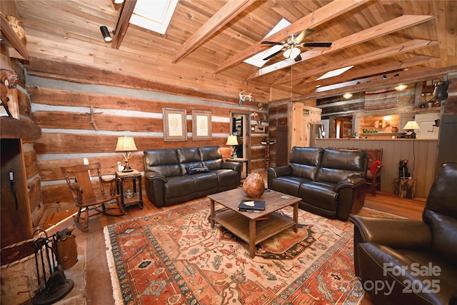 living room featuring wood walls, lofted ceiling with skylight, hardwood / wood-style flooring, ceiling fan, and wood ceiling