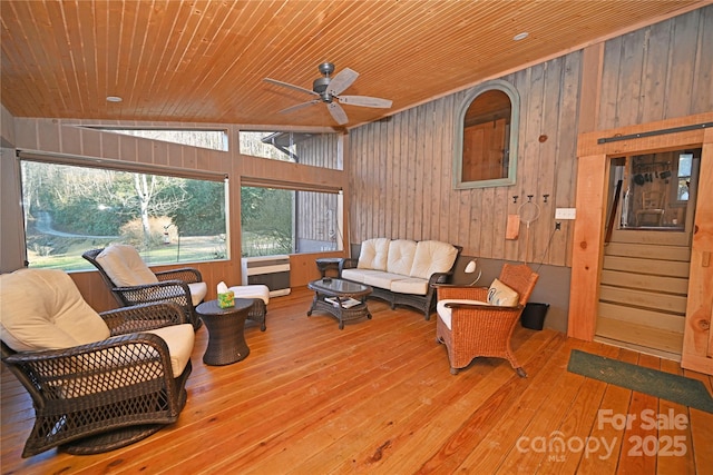 living room featuring ceiling fan, hardwood / wood-style floors, lofted ceiling, wooden walls, and wood ceiling