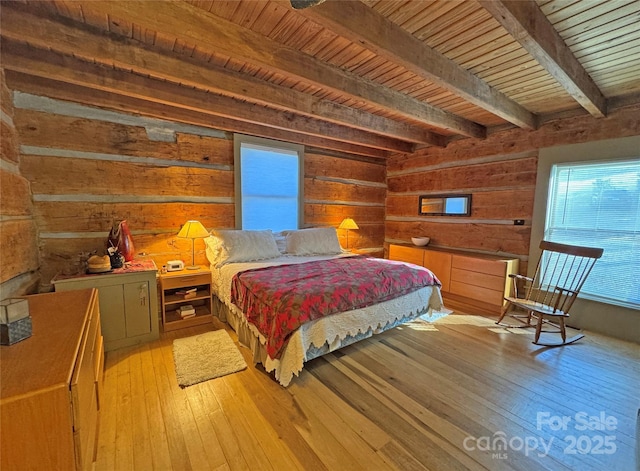 bedroom with beam ceiling, light wood-type flooring, and wooden ceiling