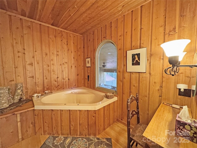 bathroom with hardwood / wood-style flooring, a bathtub, wood walls, and wood ceiling