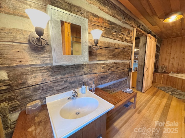 bathroom featuring hardwood / wood-style flooring, vanity, wood walls, and wood ceiling