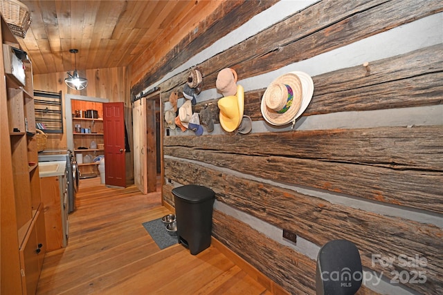 interior space with wood walls, hardwood / wood-style floors, wooden ceiling, and lofted ceiling