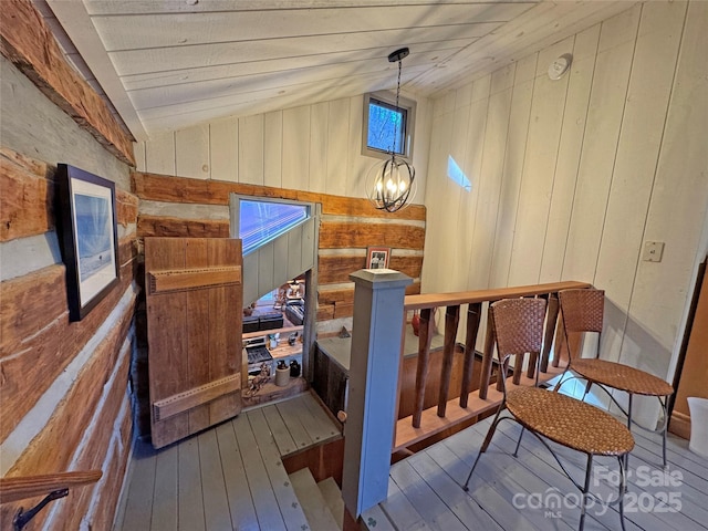 interior space with wooden walls, hardwood / wood-style flooring, and a notable chandelier