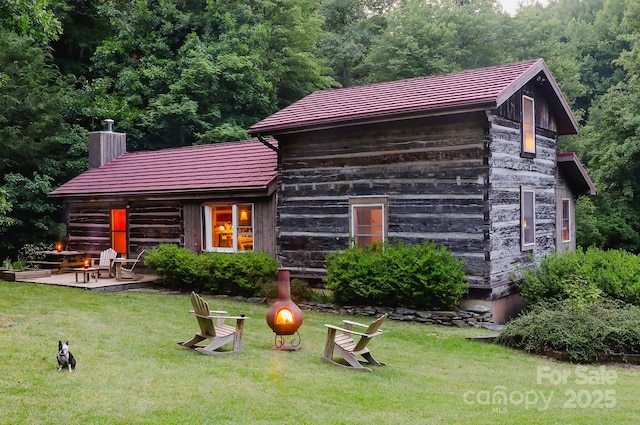 rear view of property featuring a yard and a patio