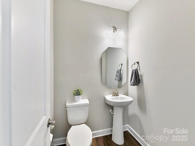 bathroom with hardwood / wood-style floors and toilet