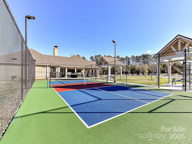 view of tennis court featuring basketball hoop