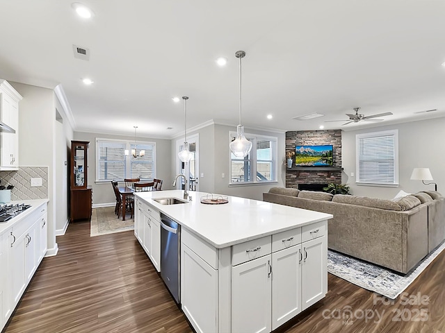 kitchen featuring sink, white cabinetry, ceiling fan with notable chandelier, a center island with sink, and appliances with stainless steel finishes