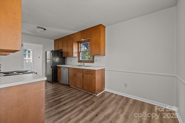 kitchen featuring a wealth of natural light, black fridge, dishwasher, and sink