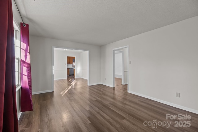 unfurnished room featuring dark hardwood / wood-style floors and a textured ceiling