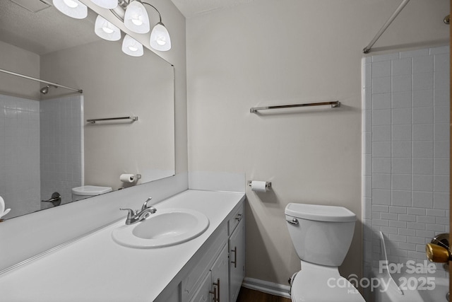 full bathroom featuring a textured ceiling, vanity, and toilet