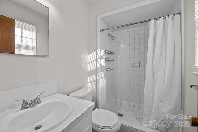 bathroom featuring toilet, vanity, and a shower with shower curtain