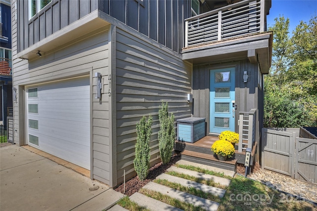 view of exterior entry with a balcony and a garage