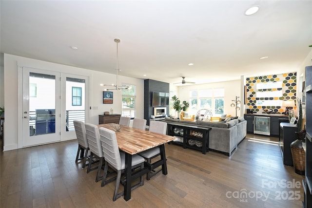 dining space with wine cooler, plenty of natural light, dark hardwood / wood-style flooring, and a chandelier