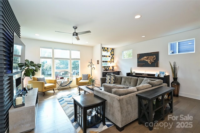 living room with ceiling fan, a fireplace, and hardwood / wood-style floors