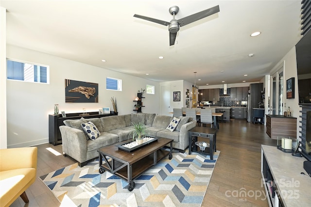 living room with ceiling fan and dark hardwood / wood-style flooring