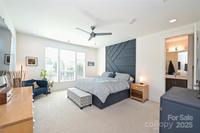 bedroom featuring ceiling fan, connected bathroom, and light carpet