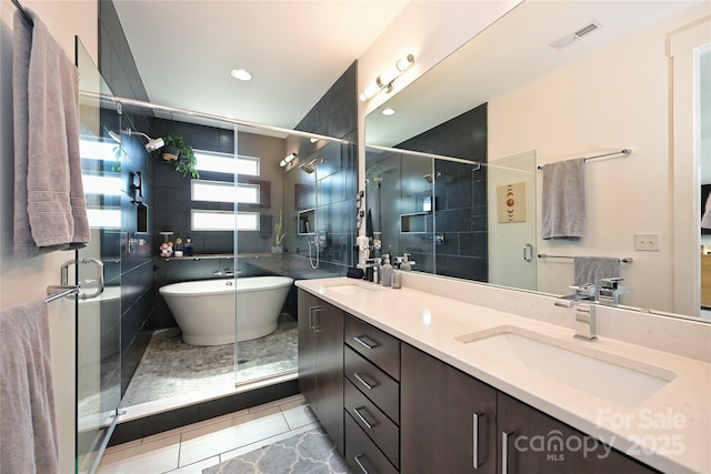 bathroom featuring vanity, shower with separate bathtub, and tile patterned floors