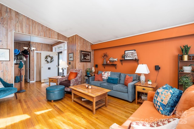 living room featuring vaulted ceiling, wooden walls, and hardwood / wood-style floors