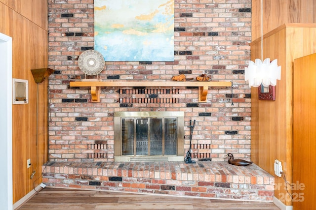 details with a brick fireplace, hardwood / wood-style flooring, and wooden walls