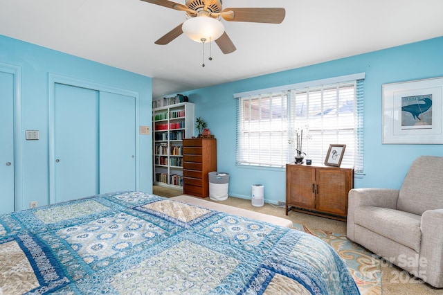 bedroom with ceiling fan, a closet, and light carpet