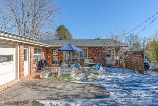 snow covered property with a garage