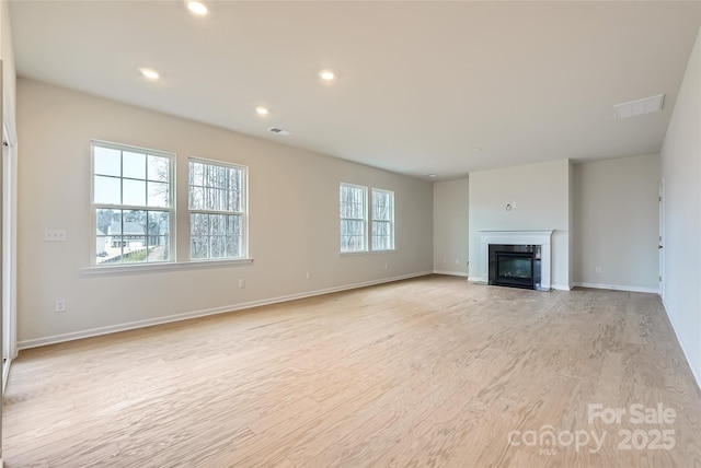 unfurnished living room with light hardwood / wood-style floors and a wealth of natural light