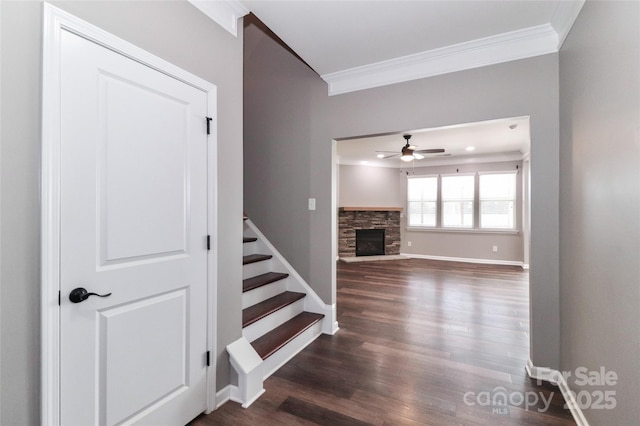 staircase featuring a fireplace, hardwood / wood-style floors, ceiling fan, and crown molding