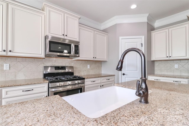 kitchen featuring crown molding, white cabinets, and appliances with stainless steel finishes