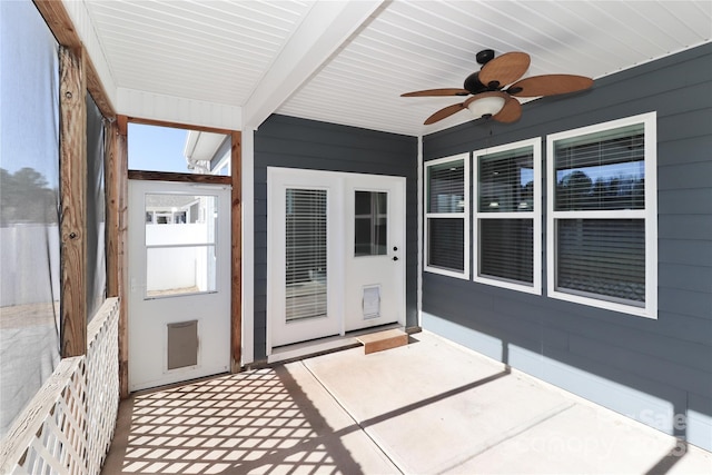 unfurnished sunroom with beamed ceiling and ceiling fan