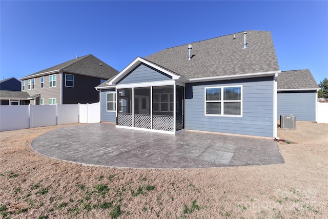 rear view of property with a sunroom, a patio, and central AC