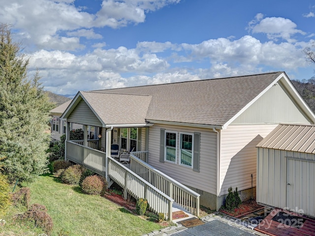 view of front of home featuring a wooden deck, a front lawn, and a shed