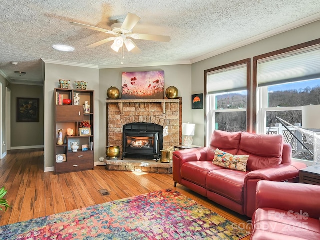 living room featuring hardwood / wood-style floors, a textured ceiling, ceiling fan, and crown molding