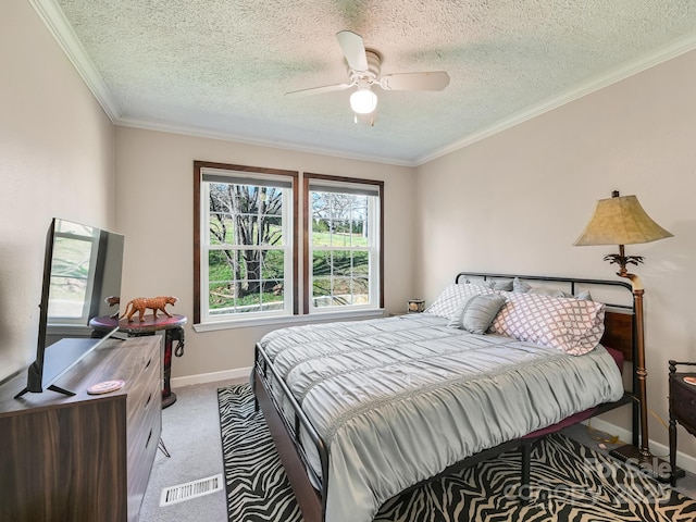 bedroom featuring light carpet, a textured ceiling, ceiling fan, and ornamental molding