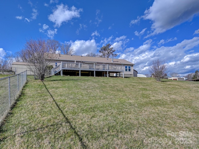 back of property with a yard and a wooden deck