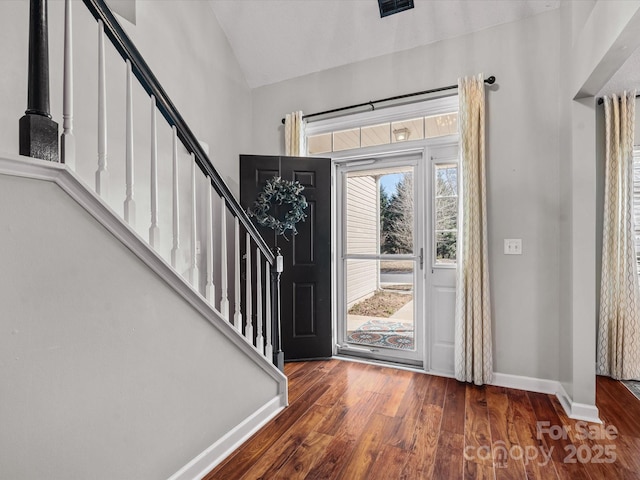 foyer entrance with lofted ceiling and dark hardwood / wood-style flooring