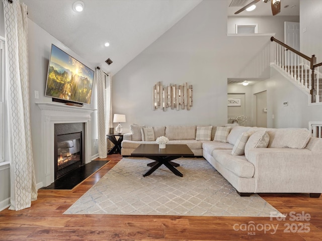 living room with high vaulted ceiling and hardwood / wood-style flooring