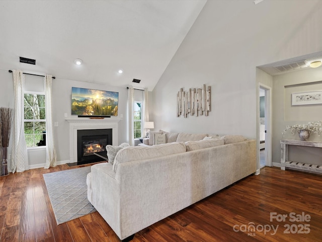 living room featuring dark hardwood / wood-style flooring and high vaulted ceiling