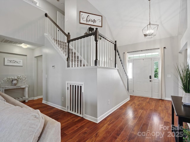 entrance foyer featuring high vaulted ceiling, a notable chandelier, and dark hardwood / wood-style flooring