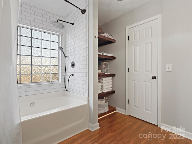 bathroom with a textured ceiling, shower / bathtub combination with curtain, and hardwood / wood-style flooring